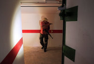 A rebel fighter inspect a tunnel in the bunker of the main Moammar Gadhafi compound in Bab Al-Aziziya in Tripoli, LIbya, Thursday, Aug. 25, 2011. Libya's rebel leadership has offered a 2 million dollar bounty on Gadhafi's head, but the autocrat has refused to surrender as his 42-year regime crumbles, fleeing to an unknown destination. Speaking to a local television channel Wednesday, apparently by phone, Gadhafi vowed from hiding to fight on "until victory or martyrdom." (AP Photo/Sergey Ponomarev)