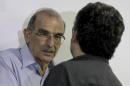 Humberto de la Calle, head of Colombia's government negotiation team, left, speaks with Ivan Marquez, chief negotiator for the Revolutionary Armed Forces of Colombia, or FARC, at the close of another round of peace talks in Havana, Cuba, Saturday, March 7, 2015. Colombia's government and the FARC have agreed to begin a pilot program for removing land mines as part of efforts to lower the intensity of a conflict that has lasted a half century. The announcement came Saturday at the end of the latest round of peace talks being held in Cuba's capital since November 2012. (AP Photo/Ismael Francisco, Cubadebate)