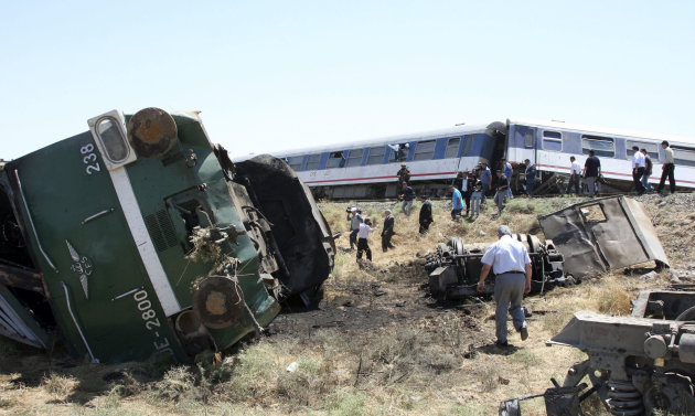 People check the destroyed carriages of a derailed train, which was carrying 480 passengers and five crew members, at al-Souda about three miles (five kilometers) from the central city of Homs, Syria,
