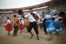In this Sunday, March 29, 2015 photo, people perform a traditional dance during the Vencedores de Ayacucho dance festival, in the Acho bullring, in Lima, Peru. The one-day dance competition was the culmination of pre-Easter celebrations held in the Andean communities, an event brought to Peru's capital because so many highlands people moved there fleeing violence. (AP Photo/Rodrigo Abd)