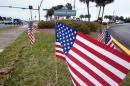 American flags stand in the median near the bridge entrance to Navarre Beach, Fla., Thursday, March 12, 2015. There's been an outpouring of support in this heavily military community following the crash of an Army Black Hawk helicopter Tuesday evening. In various parts of Navarre, 11 flags are placed, one one for each of the servicemen missing in the crash. (AP Photo/Northwest Florida Daily News, Devon Ravine)