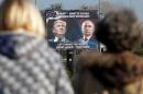 FILE PHOTO: A billboard showing a pictures of US president-elect Donald Trump and Russian President Vladimir Putin is seen through pedestrians in Danilovgrad