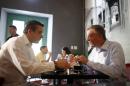 Puerto Rico's Gov. Alejandro Garcia Padilla, left, and visiting New York City Mayor Bill de Blasio, sit inside the Cafe Cuatro Sombras coffee shop where they stopped in for a cup of coffee, during a tour of Old San Juan, Puerto Rico, Saturday, Nov. 8, 2014. (AP Photo/Ricardo Arduengo)