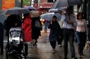 People walk with umbrellas in the rain along 9th Avenue in New York, Sunday, April 22, 2012. A spring nor'easter along the East Coast on Sunday is expected to bring rain and heavy winds and even snow in some places as it strengthens into early Monday, a punctuation to a relatively dry stretch of weather for the Northeast. The storm is atypical for April but not uncommon, said David Stark, a National Weather Service meteorologist in New York City, where 2½ to 3½ inches of rain are expected in the city with wind gusts of 25-30 mph. (AP Photo/CX Matiash)