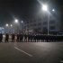 In this Monday Sept. 24, 2012 mobile phone photo, police in anti-riot suits cordon off a road near Foxconn's plant in Taiyuan, capital of Northern China's Shanxi province. The company that makes Apple's iPhones suspended production at a factory in China on Monday after a brawl by as many as 2,000 employees at a nearby dormitory injured 40 people. The facility will reopen Tuesday. (AP Photo) CHINA OUT