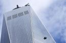 Stranded window washers hang on the side of One World Trade Center