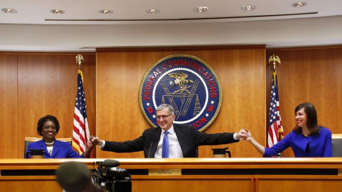 Federal Communications Commission Chairman Tom Wheeler greets commissioners Mignon Clyburn and Jessica Rosenworcel at the FCC Net Neutrality hearing in Washington