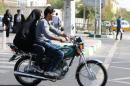 Iranian youths ride a motorcycle to bypass chronic traffic in central Tehran on October 17, 2013