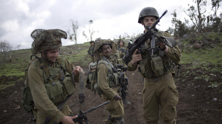 Israeli soldiers of the Golani brigade adjust their weapons during training near the border with Syria in the Israeli-controlled Golan Heights, Wednesday, Feb. 26, 2014. Hezbollah says Israel carried out an airstrike targeting its positions in Lebanon near the border with Syria earlier this week, claiming it caused damage but no casualties. The Wednesday statement was the group's first acknowledgement of the reported Monday night airstrikes. (AP Photo/Ariel Schalit)