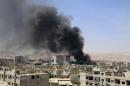 Smoke rises after what activists said were clashes between Al-Rahman corps and forces of Syria's President Assad in Al-Hajez garages, near the Damascus countryside governorate building