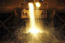 Labourer guides as slag is poured into a container at Dongbei Special Steel Group Co. Ltd. in Dalian