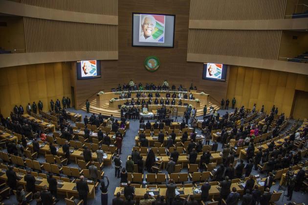 African Union representatives and ambassadors stand during a memorial for Nelson Mandela in the African Union Conference Centre in Addis Ababa