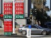 A commuter drives past a gas station signage displaying current prices for gasoline in La Jolla