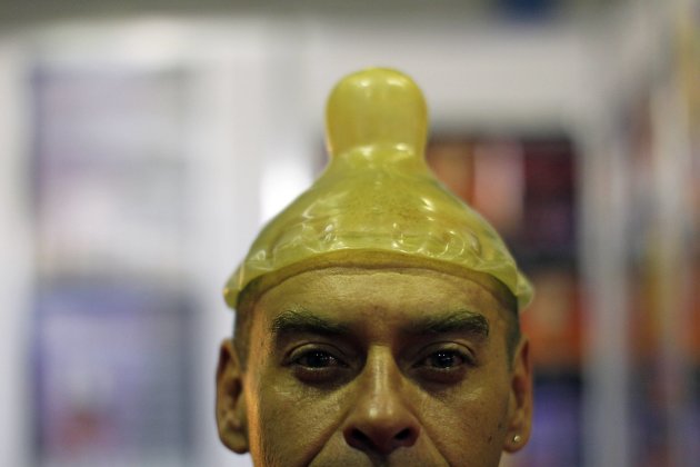 A sex shop employee poses with a condom-shaped hat during the Sex and Entertainment 2012 adult exhibition at the Palacio de los Deportes in Mexico City