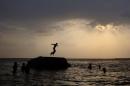 A boy prepares to jump off a rock into the waters of the Osman Sagar Lake near Hyderabad