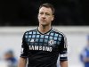 John Terry of Chelsea looks over at the Queens Park Rangers fans as they chant insults at him during an injury break in their FA Cup soccer match at Loftus Road in London