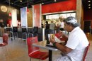 In this March 28, 2012 photo, Norman Garcia eats a burger and fries at a Burger King restaurant in Miami. Burger King launches 10 menu items including smoothies, frappes, specialty salads and snack wraps in a star-studded TV ad campaign. It's the biggest menu expansion since the chain opened its doors in 1954. (AP Photo/Luis M. Alvarez)