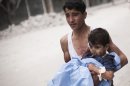 RETRANSMISSION FOR ALTERNATIVE CROP - A Syrian youth holds a child wounded by Syrian Army shelling near Dar El Shifa hospital in Aleppo, Syria, Thursday, Oct. 11, 2012. (AP Photo/ Manu Brabo)
