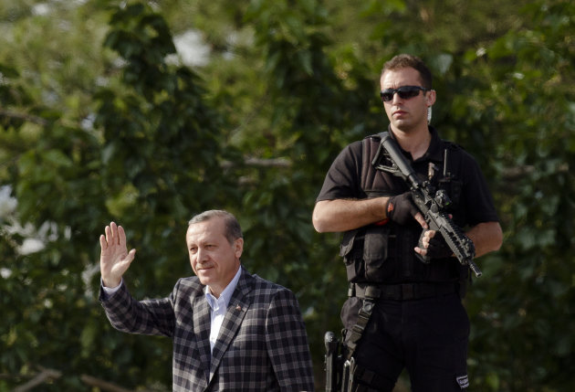 Turkish Prime Minister Recep Tayyip Erdogan waves to supporters upon arriving in Ankara, Turkey, Sunday, June 9, 2013. In a series of increasingly belligerent speeches to cheering supporters Sunday, Turkey’s prime minister launched a verbal attack on the tens of thousands of anti-government protesters who flooded the streets for a 10th day, accusing them of creating an environment of terror. Recep Tayyip Erdogan made the most inflammatory of his speeches as he arrived in the capital, Ankara. Erdogan belittled his opponents, again calling them “capulcu,” the Turkish word for looters or vandals. He made his speech in Ankara atop an open-top bus, which then drove into the city in a motorcade. (AP Photo/Vadim Ghirda)