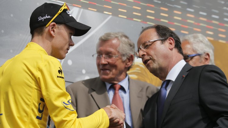 Christopher Froome of Britain, wearing the overall leader's yellow jersey, is congratulated by French President Francois Hollande, right, on the podium of the ninth stage of the Tour de France cycling race over 168.5 kilometers (105.3 miles) with start in Saint-Girons and finish in Bagneres-de-Bigorre, Pyrenees region, France, Sunday July 7 2013. (AP Photo/Christophe Ena)