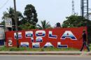 A man walks by a mural reading "Ebola is real" in Monrovia