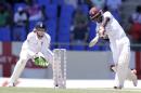 West Indies' Jermaine Blackwood hits a four off England's James Tredwell under the look of wicketkeeper Jos Buttler on day three of their first cricket Test match at the Sir Vivian Richards Cricket Ground in Antigua, Antigua and Barbuda, Wednesday, April 15, 2015. (AP Photo/Ricardo Mazalan)