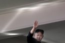 North Korean leader Kim Jong Un waves from a balcony at the end of a mass military parade in Pyongyang's Kim Il Sung Square to celebrate 100 years since the birth of his grandfather, and North Korean founder, Kim Il Sung on Sunday, April 15, 2012. Light at top is reflection of sunlight. (AP Photo/Ng Han Guan)