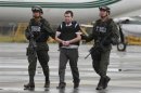 Police escort Colombian drug trafficker Daniel 'El Loco' Barrera as he is brought before the media, before being extradited to the U.S., at an airport in an anti-narcotics base in Bogota