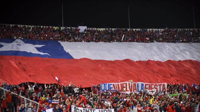 Fans hold a giant flag of Chile during a Copa America Group A soccer match between Chile and Bolivia at El Nacional stadium in Santiago, Chile, Friday, June 19, 2015. (AP Photo/Jorge Saenz)