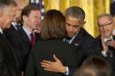 President Barack Obama hugs Susan Selke next to Richard Selke, left, the parents of Clay Hunt, after signing into law the Clay Hunt Suicide Prevention for American Veterans Act, named for Clay Hunt, which calls for evaluation of existing Veterans Affairs mental health and suicide prevention programs and expands the reach of these programs for veterans, Thursday, Feb. 12, 2015, at the White House in Washington. The bill is named for Clay Hunt of Texas, a Marine Corps combat veteran who struggled with post-traumatic stress disorder after serving in Iraq and Afghanistan and who killed himself in March 2011 at the age of 28.(AP Photo/J. Scott Applewhite)