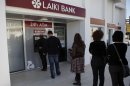 People queue to use an ATM machine outside of a Laiki Bank branch in Larnaca, Cyprus, Saturday, March 16, 2013. Many rushed to cooperative banks which are open Saturdays in Cyprus after learning that the terms of a bailout deal that the cash-strapped country hammered out with international lenders includes a one-time levy on bank deposits. The move, decided in an extraordinary meeting of the finance ministers of the 17-nation eurozone in the early hours Saturday, is a major departure from established policies. Analysts have warned that making depositors take a hit threatens to undermine investors' confidence in other weaker eurozone economies and might possibly lead to bank runs. (AP Photo/Petros Karadjias)