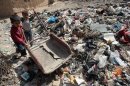 Iraqi children play on a garbage dump at the Mukhayamat settlement in north Baghdad