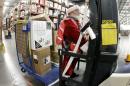 Glenn Wright, dressed in a Santa Claus costume, moves items at the Amazon fulfillment center on Monday, Dec. 1, 2014, in Lebanon, Tenn. Retailers rolled out discounts and free shipping deals on Cyber Monday, with millions of Americans expected to log on and shop on their work computers, laptops and tablets after the busy holiday shopping weekend. (AP Photo/Mark Humphrey)