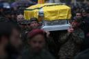 Hezbollah fighters carry the coffin of Hassan al-Laqis, a senior commander for the Lebanese militant group Hezbollah, who was gunned down outside his home, during his funeral procession at his hometown in Baalbek city, east Lebanon, Wednesday, Dec. 4, 2013. The assassination was a major breach of the Shiite militant group's security as it struggles to maintain multiple fronts while it fights alongside President Bashar Assad's forces in Syria. (AP Photo/Hussein Malla)