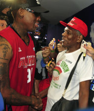 In this photo taken on Wednesday, July 18, 2012, former NBA star Dennis Rodman, left, shakes hands with his estranged father Philander Rodman Jr. after an exhibition game in Manila, Philippines. The two finally met after 42 years of separation. Philander said he was happy and surprised that his son agreed to meet him late Wednesday. (AP Photo)