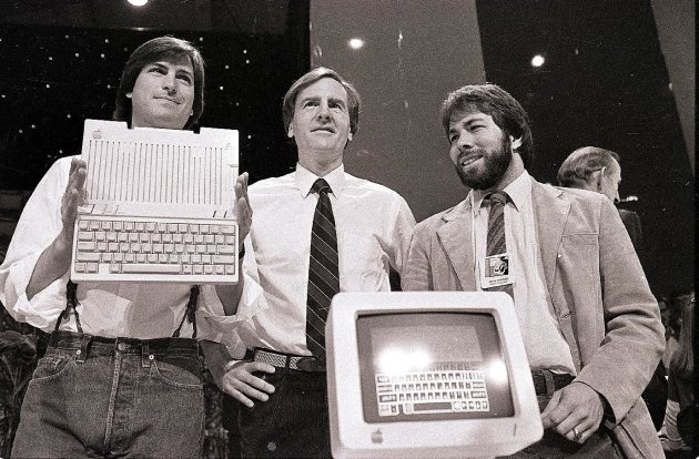 FILE - In this April 24, 1984 file photo, Steve Jobs, left, chairman of Apple Computers, John Sculley, center, then president and CEO, and Steve Wozniak, co-founder of Apple, unveil the new Apple IIc 