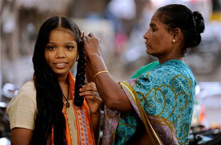 File photo of a young woman having her wet hair braided by her mother in Chennai
