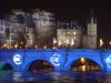 FILE - In this Dec. 31, 2001 file photo, blue lights reminiscent of the European flag and euro signs are projected on the Pont Neuf bridge over the Seine River in Paris, a few hours before midnight when euro notes and coins will replace national currencies as legal tender in 12 of the 15 European Union countries. Just three years ago, the euro was being praised as the can-do currency that had delivered unprecedented prosperity in Europe. Now, it's widely derided as a hugely flawed experiment in the wake of a debt crisis that's threatening its very existence _ an uncomfortable backdrop as the currency's notes and coins hit their first decade in circulation on Jan. 1. (AP Photo/Remy de la Mauviniere, File)