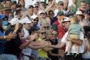 Bubba Watson, carrying his son Caleb, is congratulated by spectators after winning the Masters golf tournament Sunday, April 13, 2014, in Augusta, Ga. (AP Photo/Charlie Riedel)
