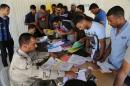 Iraqi men check in at the main army recruiting center as they volunteer for military services in Baghdad, Iraq, Wednesday, July 9, 2014, after authorities urged Iraqis to help battle insurgents. (AP Photo/Karim Kadim)