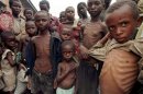 Severely malnourished Rwandan refugee children wait March 28 for food within a makeshift camp some 2..