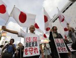 Protesters hold up Japan's national flags at an anti-China rally, attended by about 30 demonstrators, in Tokyo
