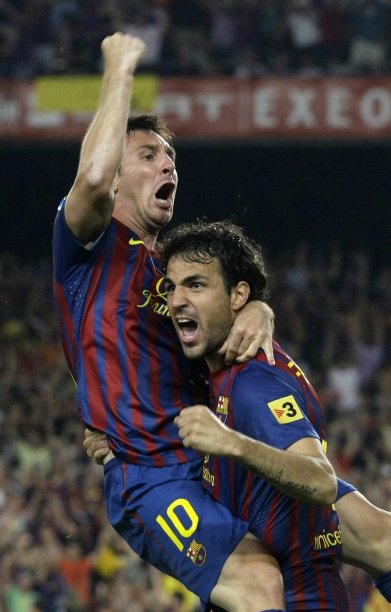 Barcelona's Lionel Messi and Cesc Fabregas celebrate a goal against Real Madrid at Camp Nou stadium in Barcelona