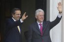 Greek PM Samaras and visiting Former U.S. President Clinton wave to reporters during their meeting in Athens