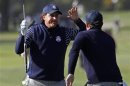 U.S. golfer Mickelson slaps hands with Bradley after Bradley's approach shot to the 11th green during the morning foursomes round at the 39th Ryder Cup matches at the Medinah Country Club i