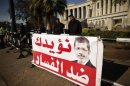 Policemen stand guard near a banner outside the constitutional court put up by supporters of Egyptian President Mohamed Mursi as they stage a sit-in, in Cairo