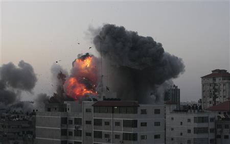 An explosion and smoke are seen after Israeli strikes in Gaza City November 18, 2012. REUTERS/Ahmed Zakot