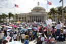 In this Feb. 18, 2013 photo, demonstrators stand outside the capitol building during a "Puerto Rico Rises" rally to protest any move to legalize same-sex marriage in San Juan, Puerto Rico. The governing Popular Democratic Party is pushing a bill through the legislature that would outlaw discrimination based on gender or sexual orientation, a step taken by about half of U.S. states. Another bill would extend a domestic violence law to gay couples. However, many Puerto Ricans remain uncomfortable with the changes. Church groups in February rallied an estimated 200,000 people against a move to include gay couples under domestic violence laws. (AP Photo/El Vocero, Sebastian Marquez Velez)