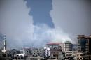 Smoke rises from an Israeli strike at a building in Gaza City, foreground, as black smoke billows from Gaza's electricity distribution company, background, after it was hit earlier by Israeli strikes in the Nusayrat refugee camp, central Gaza Strip, Tuesday, July 29, 2014. Israel struck symbols of Hamas' control of Gaza and the strip's only power plant on Tuesday, escalating its military campaign against the Islamic militant group with the heaviest bombardment in the fighting so far.(AP Photo/Khalil Hamra)