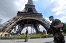 French soldiers patrol in front of the Eiffel Tower in Paris on August 14, 2013